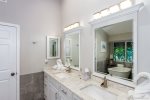 The master bathroom features dual sinks, walk in shower and a stand alone soaking tub